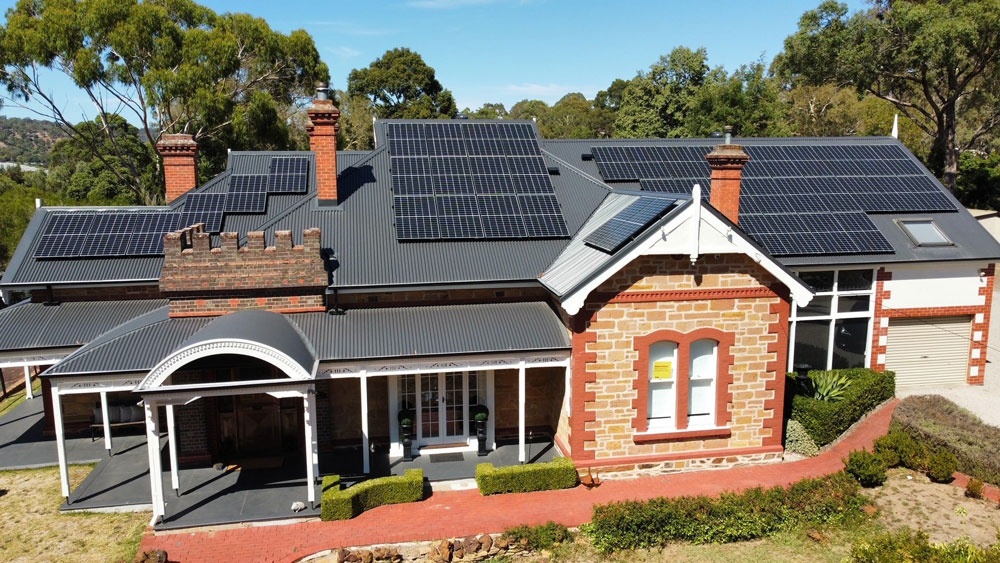 Front aerial view of solar panels across a residential character-property roof