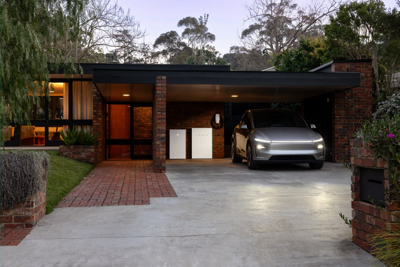 Tesla home energy equipment and vehicle in a residential setting at dusk